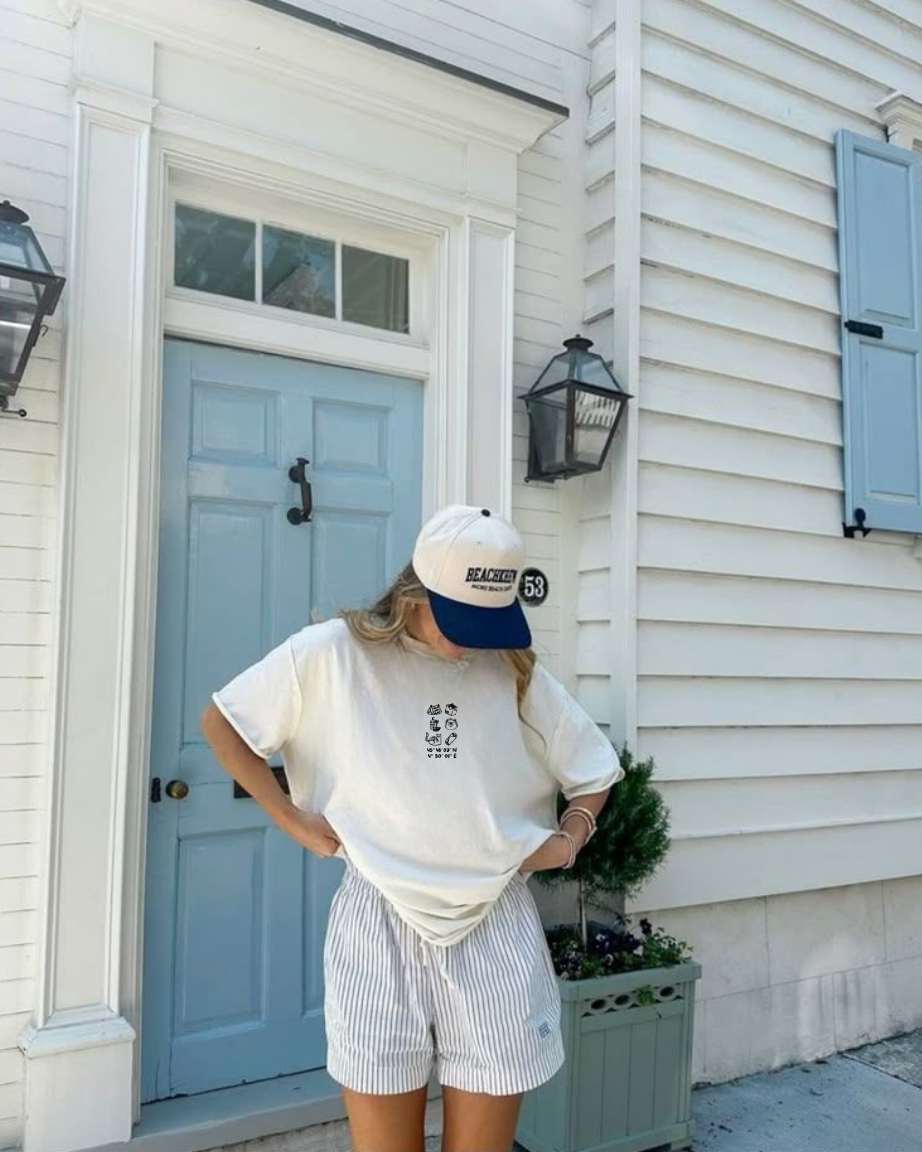 Modèle femme portant un t shirt Koeur Indigo devant l'entrée d'une maison pour photo stylée et décontractée en voyage. 